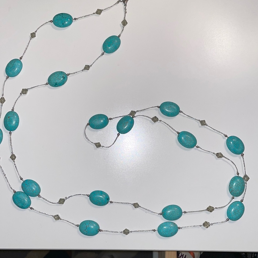 Turquoise colored beaded necklace. 56” long with clasp so it can be looped.